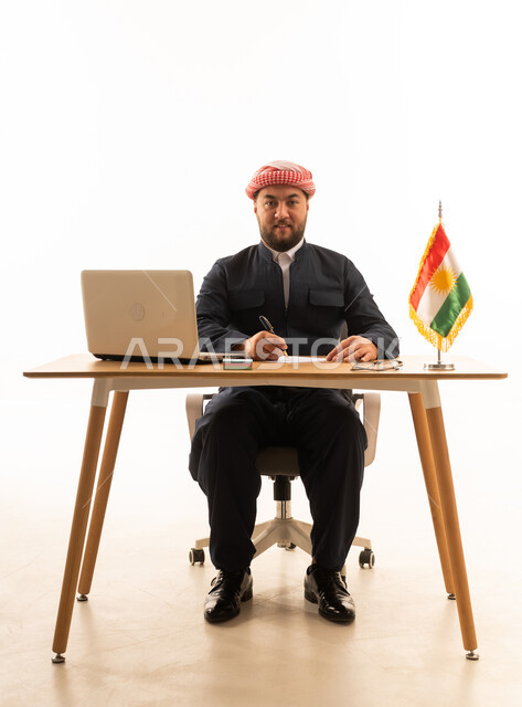 Kurdish Man at Office Desk with Laptop and Flag