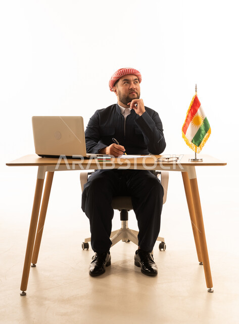 Kurdish Businessman at Desk with Flag and Laptop