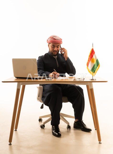 Kurdish Man Working at Desk with Kurdistan Flag