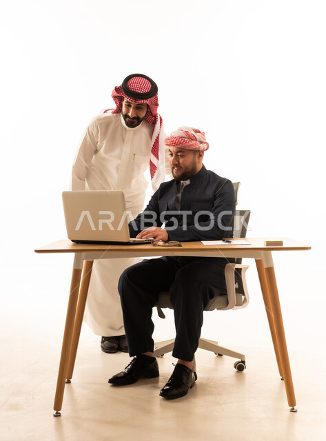رجل سعودي وكوردستاني يعملان على لابتوب بخلفية بيضاء