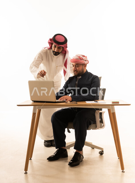 رجل سعودي وكردي يعملان معاً على المحمول
