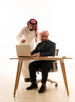 Saudi and Kurdish Men Working Together on Laptop