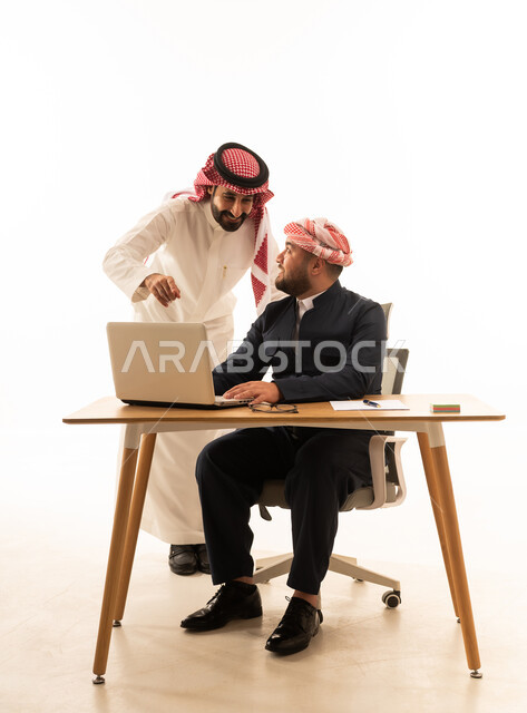 رجل سعودي ورجل كوردستاني يعملان على اللابتوب