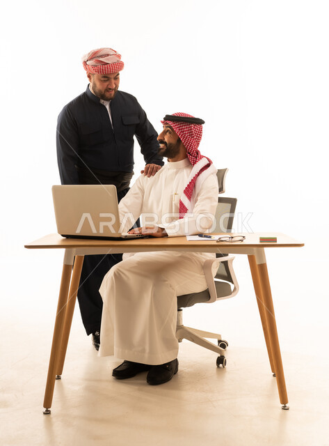 رجل أعمال سعودي وكردي يعملان على الحاسوب