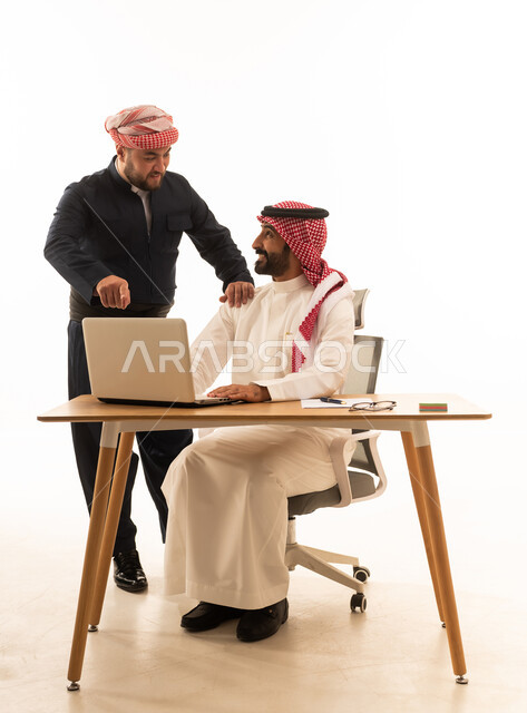 رجل سعودي وكردي يتعاونان في العمل خلف المكتب