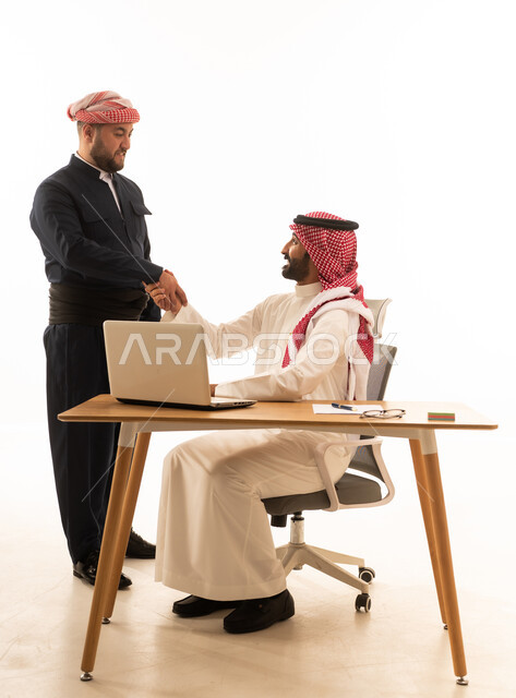 مصافحة رجل أعمال سعودي ورجل كردي بالزي التقليدي