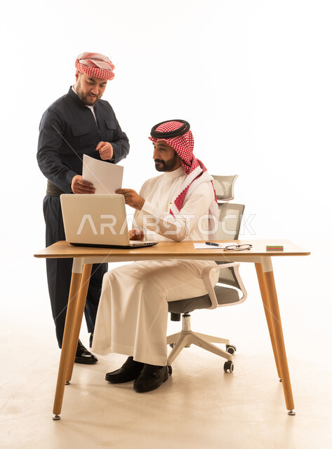 رجل أعمال سعودي وكردي يعملان على مكتب