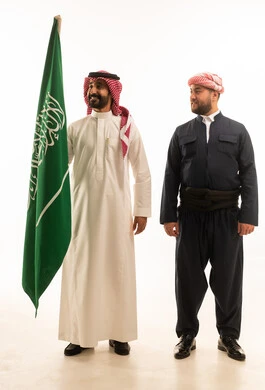 رجل سعودي وكردي مع العلم السعودي بخلفية بيضاء
