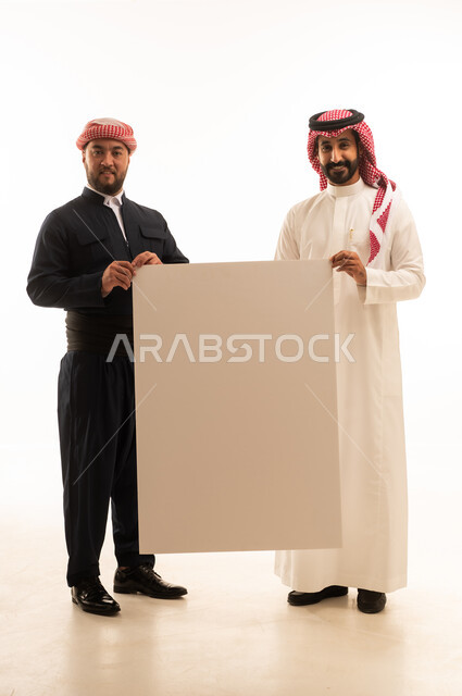 رجل سعودي وكردي يحملان لوحة بيضاء فارغة