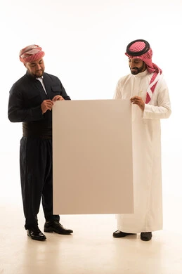 رجل سعودي وكردي يحملان لوحة بيضاء فارغة