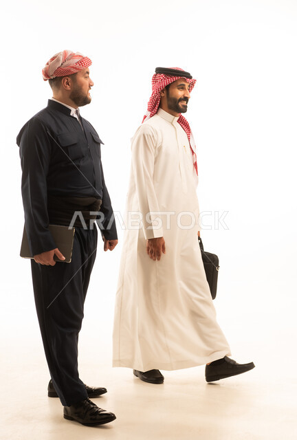 رجل أعمال سعودي وكردي يسيران على خلفية بيضاء