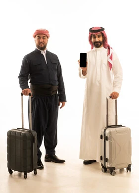 رجل سعودي وكردي مع حقائب سفر وهاتف ذكي