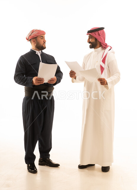 رجل سعودي وكوردستاني يناقشان أوراق عمل في الاستوديو