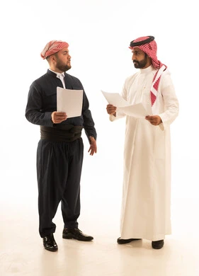 رجل سعودي ورجل كردي بالزي التقليدي يحملان أوراق عمل