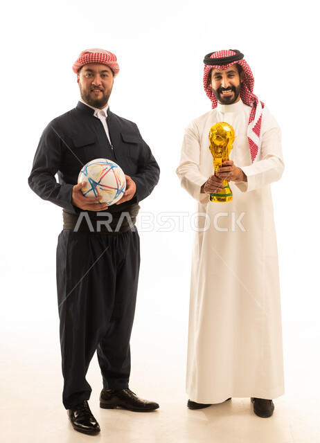 رجل سعودي وكردي مع كأس البطولة وكرة قدم