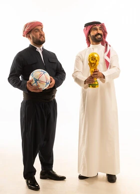 رجل سعودي وكردي مع كأس العالم وكرة قدم