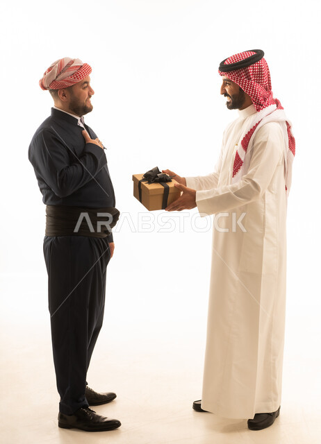 رجل سعودي وكوردستاني يتبادلان الهدايا بخلفية بيضاء