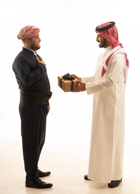 رجل سعودي وكوردستاني يتبادلان الهدايا بخلفية بيضاء
