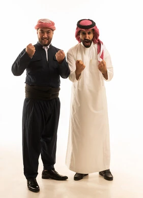 رجل سعودي وكردي باللباس التقليدي في وضعية تشجيع