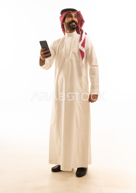 Saudi Man in Thobe Using Smartphone on White Background