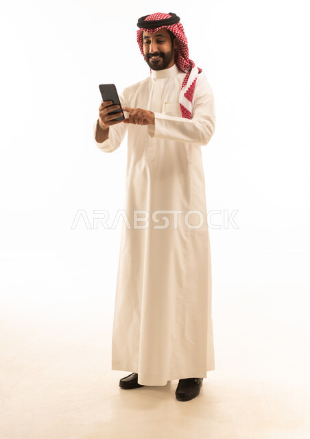 Saudi Man in White Thobe Using Smartphone on White Background