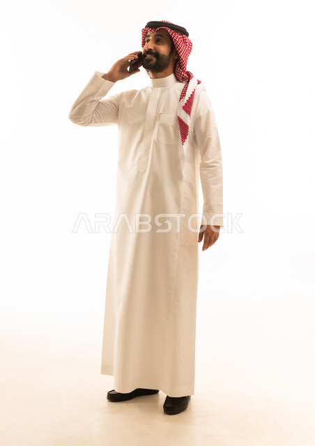 رجل سعودي بالثوب التقليدي يتحدث عبر الهاتف