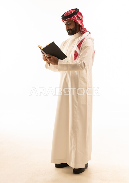 رجل سعودي يقرأ كتاباً على خلفية بيضاء