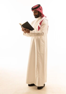 رجل سعودي يقرأ كتاباً على خلفية بيضاء رجل سعودي يقرأ كتاباً على خلفية بيضاء