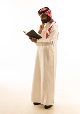 رجل سعودي يقرأ كتاباً بخلفية بيضاء
