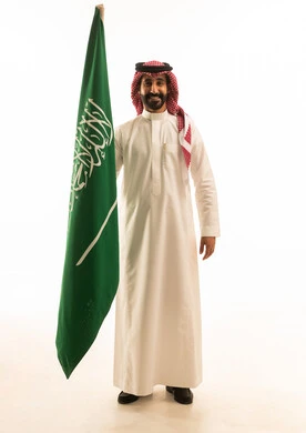 Saudi Man in Traditional Thobe Holding National Flag