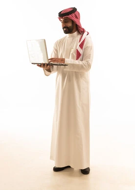 رجل سعودي يستخدم اللابتوب بخلفية بيضاء
