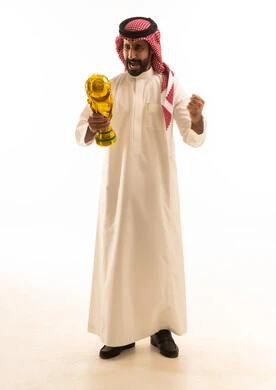 رجل سعودي يحمل كأساً ذهبياً ويحتفل بالفوز