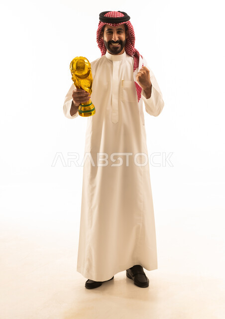 رجل سعودي يحمل كأساً ذهبية بخلفية بيضاء