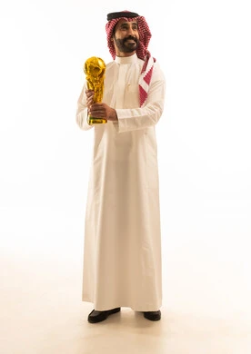 رجل سعودي يحمل كأس العالم الذهبي في الاستوديو