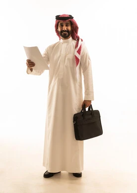 رجل أعمال سعودي بالزي التقليدي يحمل أوراقاً وحقيبة عمل رجل أعمال سعودي بالزي التقليدي يحمل أوراقاً وحقيبة عمل
