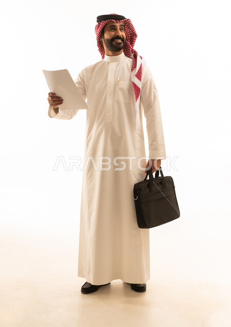 Saudi Businessman in Thobe Holding Documents and Bag
