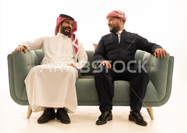 رجل سعودي وكردي يضحكان على الأريكة في الاستوديو