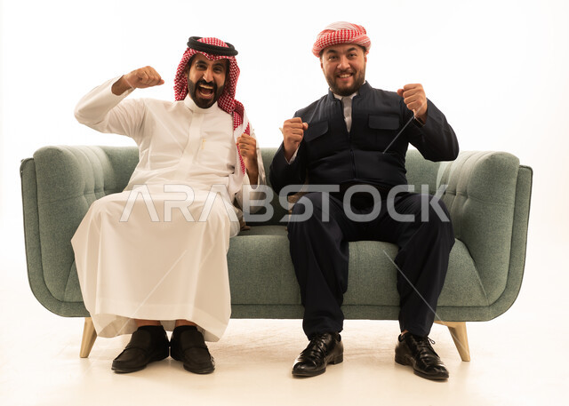 رجل سعودي وكردي يحتفلان بالفوز على الأريكة