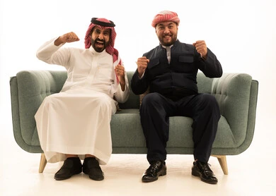 رجل سعودي وكردي يحتفلان بالفوز على الأريكة