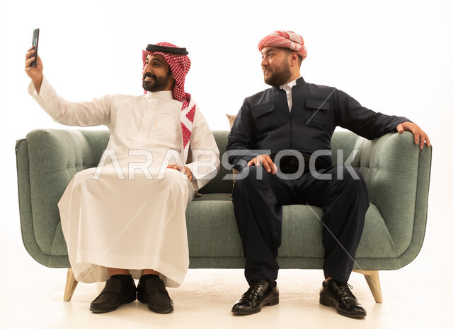 رجل سعودي وكردي يلتقطان سيلفي باللباس التقليدي