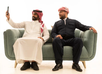 رجل سعودي وكردي يلتقطان سيلفي باللباس التقليدي