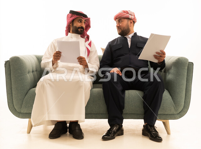 Saudi and Kurdish Men with Documents on Green Sofa