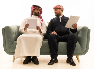 Saudi and Kurdish Men with Documents on Green Sofa