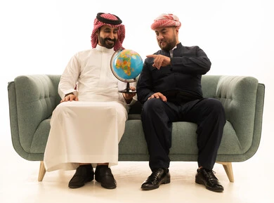 رجل سعودي وكردي مع مجسم الكرة الأرضية