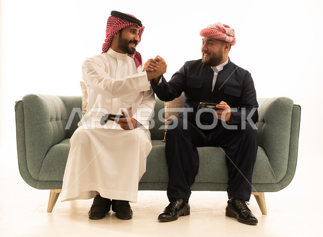 رجل سعودي وكردي يتصافحان أثناء لعب الفيديو