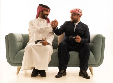 رجل سعودي وكردي يتصافحان أثناء لعب الفيديو