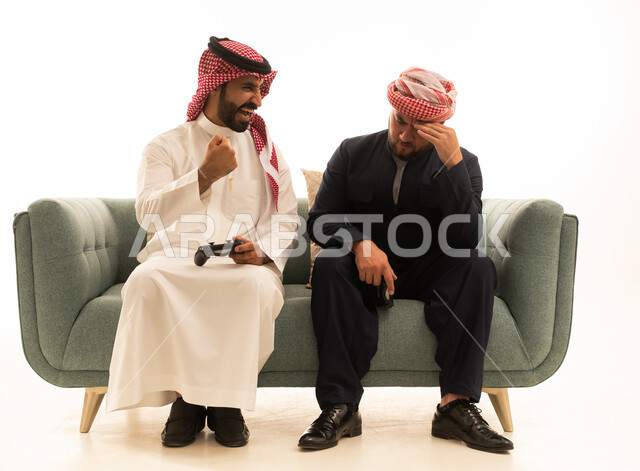 رجل سعودي وكوردستاني يلعبان ألعاب الفيديو على الأريكة