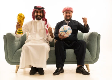 سعودي وكردي يحتفلان بفوز كرة القدم مع الكأس