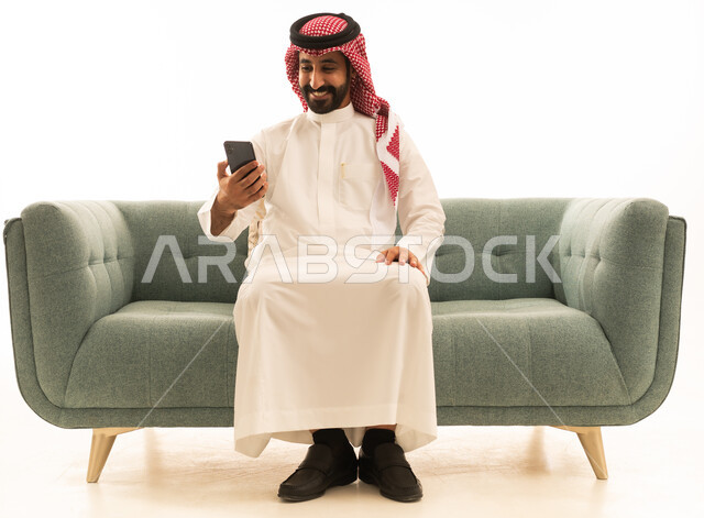 Saudi Man Using Smartphone on Green Sofa