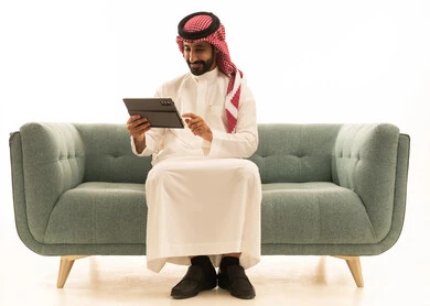 Saudi Man Using Digital Tablet on Green Sofa Studio